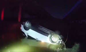 Police officers rescue a woman who was trapped in a car that had been driven off a bridge