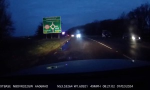 Pedestrian Walks Across Dark Morning Road