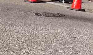 Worker Chucks a Brick From Manhole