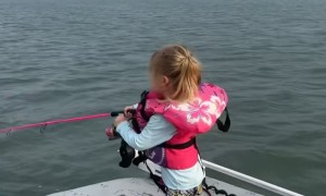 Girl Holds on Tight While Reeling in Fish