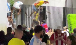 Soccer Fans Climb Over Fence at Stadium