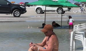 Man Shaves Legs On Beach