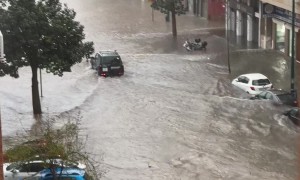 Car Drives Through Flooded Street in Spain