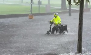 Bicycle Courier Rides Through Flooded to Street to Make Delivery