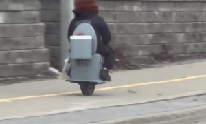 Man Riding a One-Wheeled Toilet Scooter