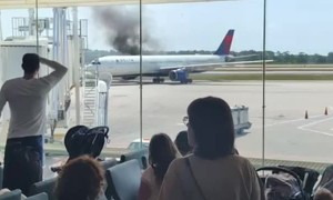 Crowd Watches Delta Plane Catch Fire From Airport Terminal