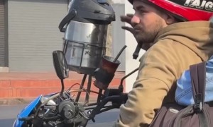 Motorcycling Man Drinks From Beverage Dispenser