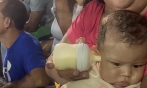 Sports Game Distracts From Bottle Feeding Baby