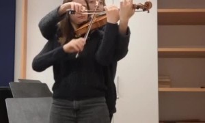 Two Musicians Perform on Single Violin