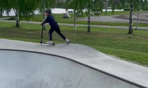 Boy Faceplants While Scootering In Skatepark