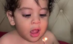 Little Boy Trying His Best to Blow Out Candles
