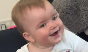 Baby Laughs at His Mom Reading a Book