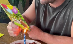 Guy Reading a Birthday Card as the Candle Lights It on Fire