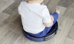 Boy Riding Robot Vacuum Bumps Toes