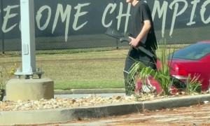 Man Walking Public Street With A Gun