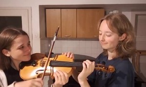 2 Girls Play 1 Violin While A Guy Plays Piano Laying on His Back