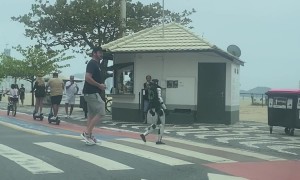 Man Pilots Walking Robot Across Pedestrian Crossing