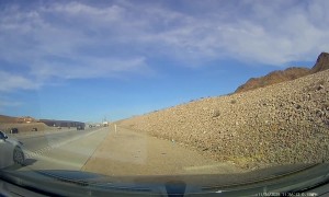 White Sedan Merging Onto Highway Crashes Into Soil Truck