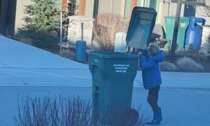 Boy Struggles With Trash Can in High Winds