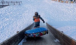 Kid Stumbles Off The Sledding Ramp