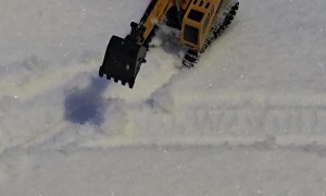 Miniature Excavator Works To Clear Snowfall