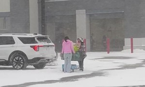 Kind Girl Helps Stranger Push Shopping Cart Through Snowstorm