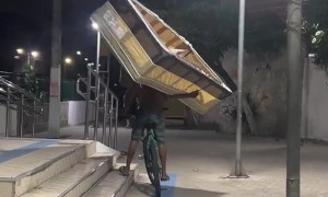 Man Carries a Bed While Riding a Bicycle