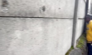 Football Fans Watch Game Through Holes In Concrete Wall