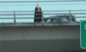 Bridge Monk Stands Ominously Over Oncoming Traffick in Portland