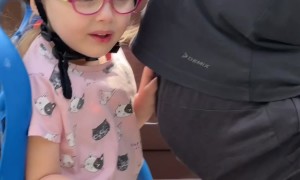 Girl on Bike Biting Dad