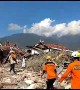 Rescuers walk through piles of rubble in aftermath of deadly Indonesia earthquake