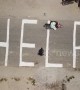 Indonesians chalk large "HELP" on ground as authorities fear more than 5,000 still missing