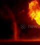 Dust devils swirl next to raging bonfire