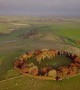 Dawn breaks over ring of autumnal trees in the Peak District in breathtaking drone footage