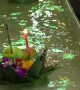 Worshippers send candle-lit baskets down a flume for Loy Krathong festival in Thailand