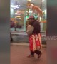 Man strolls down street in eastern Chinese city with dog balanced expertly on his head