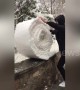 Man 'folds' snow on top of a wall into giant snowball