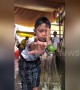 Dizzy kids try to flick lime from bottle top in amusing party game