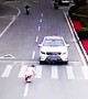 Polite girl bows to car driver after he stops to let her cross the road