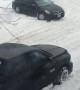 Stuck Car Struggles on Snowy Street