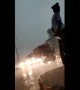 Neither wind nor rain stops this Indian traffic cop from doing his job