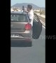 Reckless passenger leans from car door to take selfie on busy road in the Canary Islands