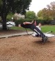 Threading the needle! Acrobat leaps through hoop spinning on playground turntable