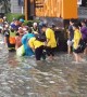 School children wade through water after flash floods in Bangkok