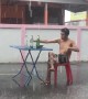 Wind and rain won't stop this Thai man from popping a beer and noodles