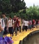 Teachers use tables to build bridge so students can walk across flooded courtyard in China