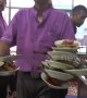 Talented waiter carries 17 food-filled plates at once in an Indonesian restaurant