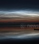 Shiny noctilucent clouds 'dance' in the skies above lake in the Netherlands