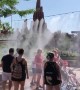 Families visiting Disneyland Paris cool down under water mist during European heatwave