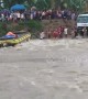 Passengers watch on as bus flips over in raging river in the Philippines